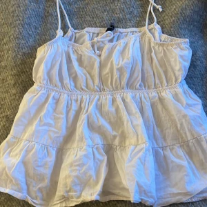 Vit topp - Säljer denna volang topp från HM, i storlek 36. Går att byta längd på snörena💗