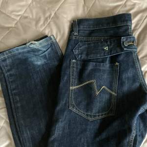 Mörkblåa jeans från Rabiez. Köpte i nyskick, har använts mycket men de syns bara där nere. Säljer då jag har tröttnat på dom🙃 Cool och unik baksida, mid/low waist och straight leg! Midjemått rakt över: 42cm❤️säkert coola baggy om man är mindre!