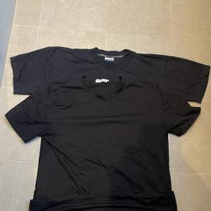 två svarta t-shirts, översta är vintage med tjockare krage, andra är mer träningsmaterial