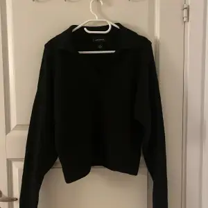 En svart stickad tröja med krage