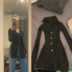 Svart lång right tröja - Lång svart tröja med bruna knappar. Jätte fin!