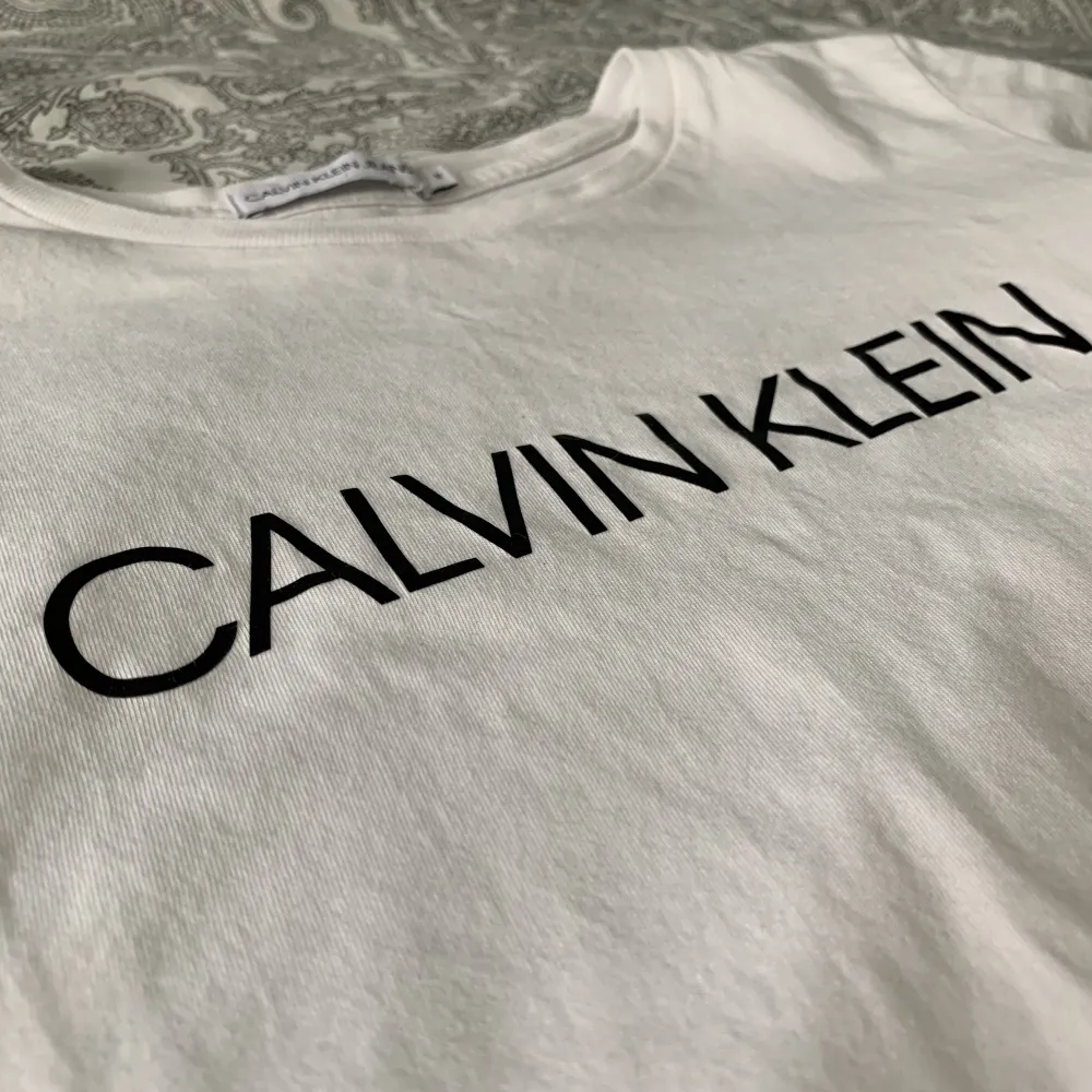 Jag säljer nu min vita Calvin Klein t-shirt då den är för liten. Den är inte använd så många gånger så den är i bra skick. Storleken är 12y vilket motsvarar xxs/xs. . T-shirts.