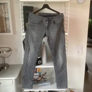 Ett par gråa dondup jeans i modell George och storlek 33. En hyfsat stor spricka på baksidan men bra lagning så att det inte är så synligt. Säljer för att dem blivit för små för mig.