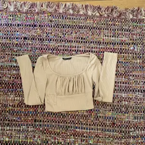 Säljer denna söta beiga långärmade tröjan med en söt detalj vid bröstet. Storlek xs från shien. 💛