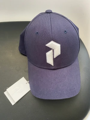 Helt ny keps från Peak performance  - Helt ny keps från Peak performance. Mörkblå färg Tags sitter kvar!