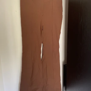 Bruna kostymbyxor - Utsvängda bruna kostymbyxor som är elastiska 