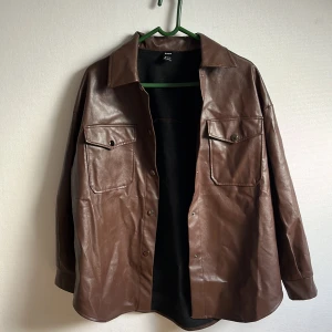 Brun jacka i fakeskinn  - Säljer en brun ”skinn” jacka från Shein, använd ett fåtal gånger, tunn, passar bar till våren och tidig höst. Kan mötas upp eller postas