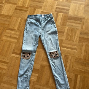 Barn jeans med leoparder - Det är leoparder på knäna och de är ljusa.