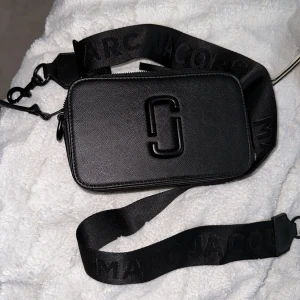 Marc Jacobs fake väska i svart - En helt ny och fräsch fake Marc jacobs axelväska i hel svart, bandet är också svart. Den är helt oanvänd. Priset kan diskuteras! 