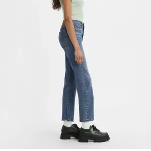 Ett par superfina Levis jeans i blå färg med slitningar längst ner. Raka ben men lite mer croppad. I modellen “WEDGIE RAKA JEANS”