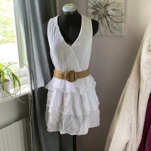 Vit volang klänning - Vit volangklänning i ett luftigt och skönt material. Bältet är tillhörande. Använd en gång