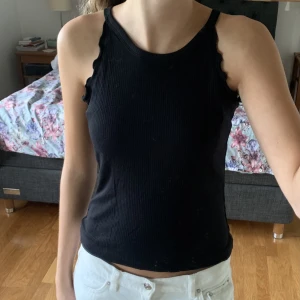 Linne med volangkant  - Svart tunt linne med volangkant vid ärmen, ribbat tyg. Är från Lindex i barnstorlek men är stor så den passar xs-s💗