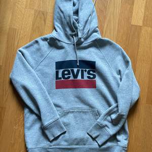 En grå Levis hoodie i storlek M. Sparsamt använd med inga tydliga tecken på användning.  Skriv för fler frågor eller bilder