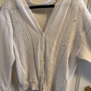 Stickad tröja - Super söt stickad tröja med lite mönster/broderi och knappar💗 Ger Rory Gilmore och höst vibes. Den har bara pärlor på ena sidan så man kan välja om man vill sy dit på andra sidan eller ta bort dom helt.