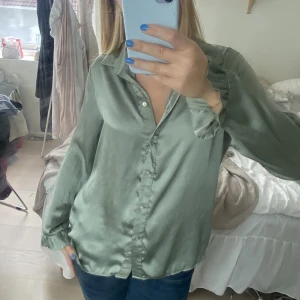 Tunn blus med detalj vid armarna - Blus med volang vid armarna 