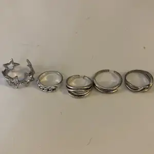 Fem stycken silverfärgade järn ringar i blandad stil.