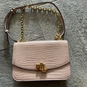 Ralph Lauren väska - Säljer denna fina väska som jag fått i present. Inköpt på Johnells år 2020. Den kommer inte till användning och har endast använt den 2 gånger så den är som ny! Vet inte nypris. 
