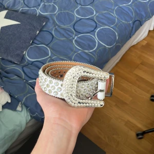 Tuttolente bälte - 44 inch tuttolente bälte nästan helt nytt i vit. Alla diamanter är på och säljs inte längre på hemsidan