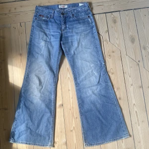 Lågmidjade jeans - Lågmidjade jeans i ljus tvätt med slitna detaljer. Perfekt skick! Bred utsvängd modell❤️ Storleken motsvarar en M. Skriv vid funderingar/för mått.  Kolla in min profil för andra snygga jeans! 