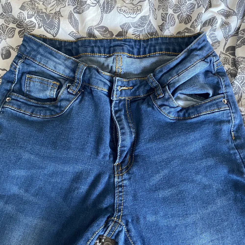 Låg midjade jeans en liten lös tråd längst ner på höger ben som går att klippa av . Jeans & Byxor.