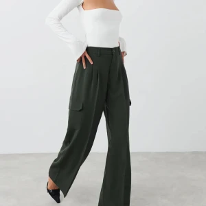 Cargotrousers, Gina Tricot - Supersnygga byxor i khakifärg. Lågmidjade och supernice fit! Oanvända. Storlek 38, men skulle säga att de passar 36 bra också. 