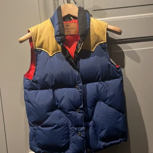 Jackson Hole original stl 10-12 år - Bästa original dunvästen från Jackson Hole med ok i äkta läder. Snygg , varm och slitstark är kännetecknet för Jackson Hole. Märket präglat bak i skinnet på oket. Två praktiska fickor med dragkedjor på insidan. Storlek 140/146 ca 10-12 år. Nypris 2995kr
