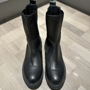 Stövlar - Hej! Säljer mina svarta stövletter (Leather profile chelsea boots) i storlek 39 från nakd, endast använda en gång 😊 Nypris är 1199kr, de är supersköna men inte riktigt min stil tyvärr.
