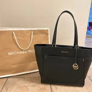 Michael Kors väska  - Säljer en äkta Michael kors väska jag fick i present av min pappa då jag har en nästan identisk. Nypris 168 dollar = ungefär 1750kr. Säljer för 1300. Helt oanvänd. Lappar är kvar. Kvitto o påse finns också. Pris kan diskuteras