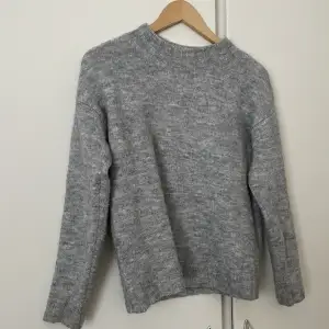 En stickad grå tröja. Perfekt för vintern. Storlek Xs, bredd 48 cm och längd 55 cm.