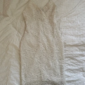 Klänning - Super fin vit klänning med spets broderi som formar kroppen så fint och smakat ner midjan. Den sträcker sig till knäna och har inga skador eller märken🌸