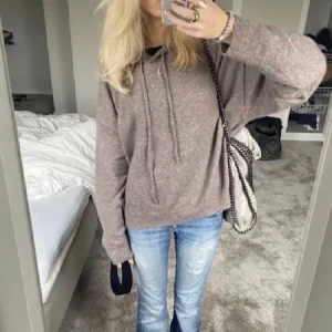 Stickad hoodie  - Stickad hoodie från Lindex, verkligen super gosig och där av blivit använd mycket som gett den lite noppror. Annars ej trasig på något sätt. 