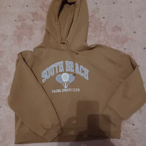 Brun lila hoodie - Säljer denna fina bruna hoodie med lila tennis tryck då den inte kommer till användning, den är i storlek medium och bra skick!  Köparen står för frakten och jag ansvarar ej för postens slarv. Bara att höra av er cid frågor (: