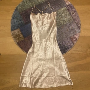 Gina tricot klänning - Har använt ett par gånger. Champagne-färgad. Tunt material men inte genomskinlig. ”Fladdrigt” vid brösten och öppen rygg med fin snörning