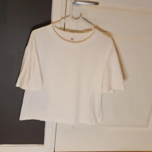 Vit top med volang i ärmen - Obs rosa fläck längst nere, se bild. Japansk M, närmare svensk lös S. 