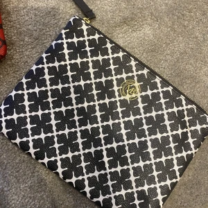By malene Birger väska  - Säljer 2 väskor/clutch från By malene Birger.  En svartvit väska 17*25 och en liten större väska-rödsvart  25,5*18 med axelrem till. 