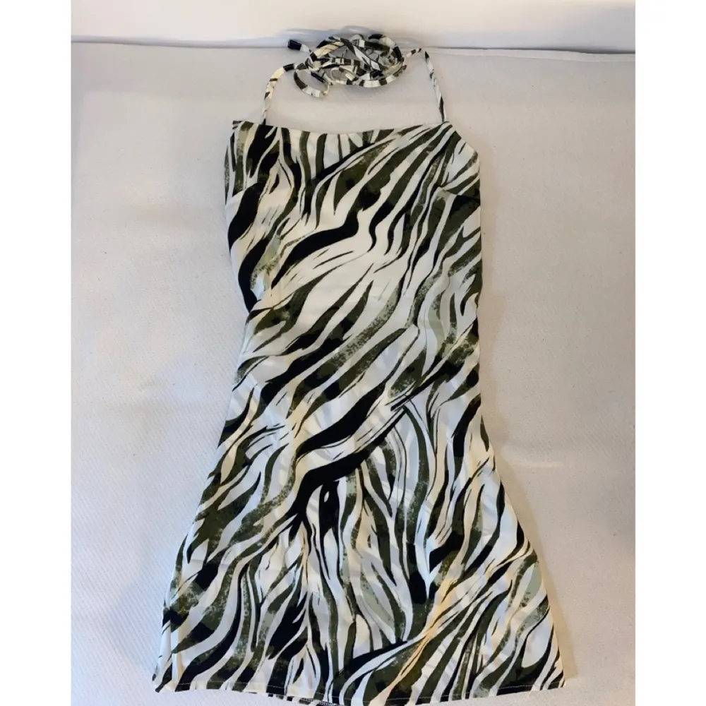 Säljer min helt oanvända festklänning i zebramönster! Den går i vitt, svart och lite grönt. . Klänningar.
