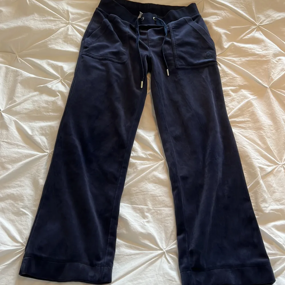 Juicy Couture byxor i mörkblå. Damstorlek XS med upplagda ben, innerbensmått 64 cm.  Köparen står för frakten. Nypris 1200 kr.  Nästan oanvända, inget slitage. . Jeans & Byxor.