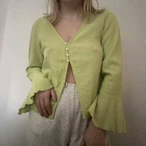 Långärmad tröja med slits och vida ärmar - Långärmad tröja från stradivarius i linnematerial. Den har vida volangärmar och knappar i mitten. Jättecool men för cool för mig så får inte användning för den. Lappen sitter kvar då den endast är provad på. 