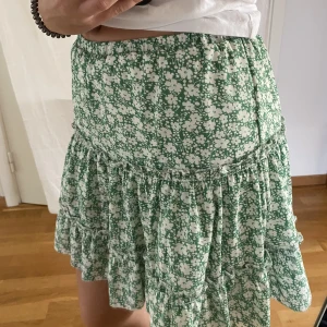 Kjol - Söt kjol i blommigt mönster. Finns byxa inuti. Använd ca. 1 gång.