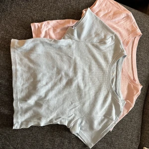 Två croppade toppar i pastell blå och rosa - Croppade, pastell blå och pastell rosa. Väldigt sköna och lätt ribbade i materialet, säljer båda tillsammans 