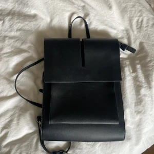 Ryggsäck carin wester - Snygg ryggsäck från Carin Wester i skinnimitation! Köpt för ungefär ett år sen men har inte kommit till använding och är i nyskick! Får plats med 13 tum dator inuti. Säljer för 320 kr, orginalpris 599kr