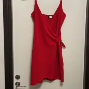 Röd omlott klänning från H&M köpt för ett par år sen men endast använd 2 ggr så nästan helt ny. Säljs för att den inte kommer till användning. Inga defekter  Skriv i DM för frågor. Köparen står för frakten 