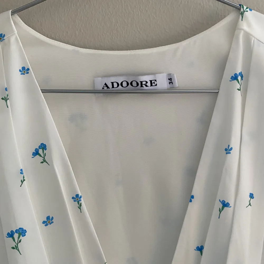 Oanvänd vit adoore klänning i modellen  Amalfi.  Storlek: 34 (längden är justerbar). Klänningar.