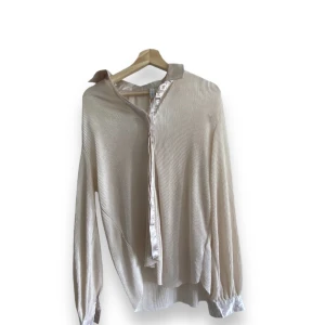 Beige skjorta  - Säljer den här fina oanvända beiga skjortan. Den är tunn och har satin tyg vid knapparna. 