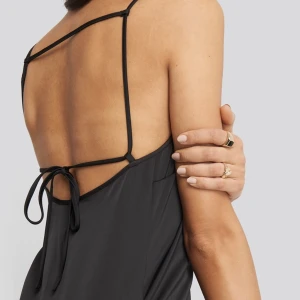 Klänning  med knyt i ryggen - Svart klänning med knyt i ryggen från NA-KD nypris 439