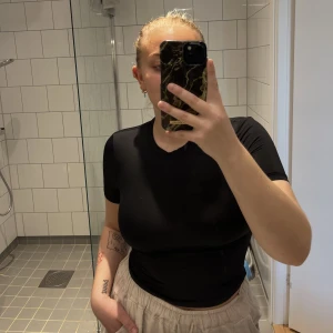 Tshirt - Svart T-shirt av liknande badräktsmaterial. Den är verkligen superskön, inte alls genomskinlig och sitter som en smäck. Har dock blivit för liten för mig nu, knappt använd. Tips till er med djur så fastnar inte djurhår på den 🙏  Katt finns i hemmet <3 