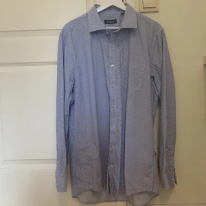 Ljusblå skjorta  - Ljusblå skjorta från dressman. Storlek XL (43/44). Väldigt bra skick, aldrig använd. Skicka meddelande vid frågor eller fler bilder 