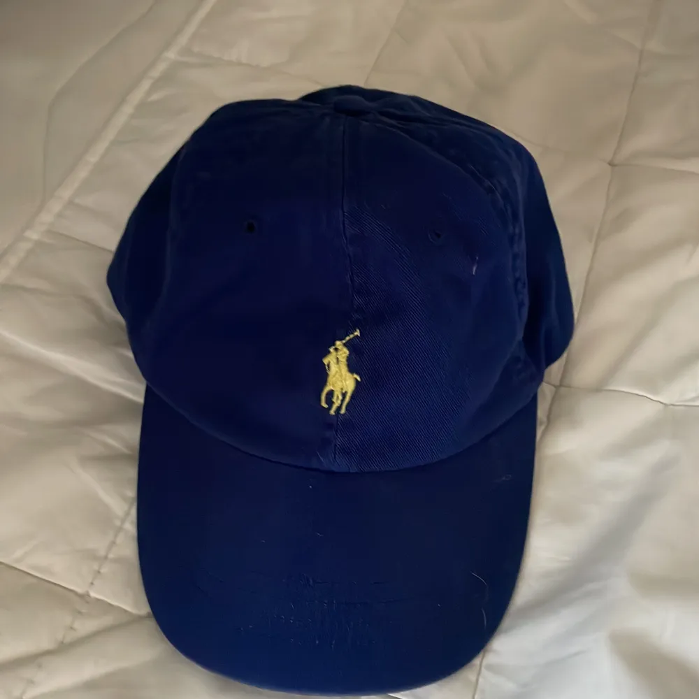 Mörkblå Ralph lauren keps med gul märke, fint skick, nypris 499. Övrigt.