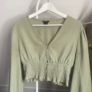 Grön blus - Säljer denna jättesöta tröja/blus från monki då den aldrig kommer till användning längre. I storlek S och är i bra skick bortsätt från lite slitning längst ner på tröjan!💓