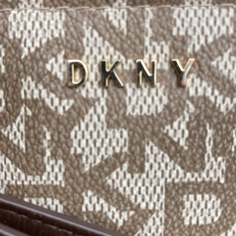 Fin clutch DKNY  Inga slitage  22x 14cm  Perfekt till festen !  Monogramtryck DKNY . Väskor.